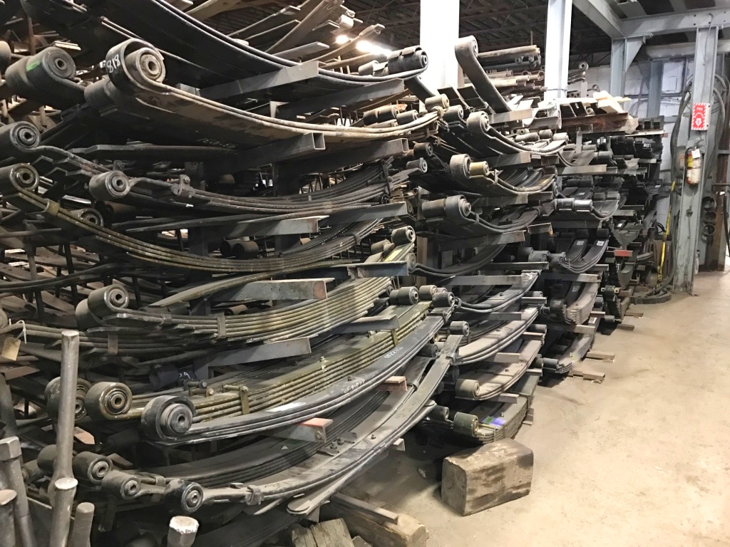 Ressorts à lames de suspension pour camions lourds empilés en atelier.